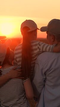 Happy farmer family in field. Father, mother, child daughter, happily embracing at sunset. Loving parents, little girl in their arms, enjoying nature in wheat field sun sky. Dream about happy future