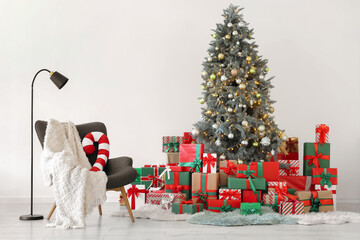 Obraz premium Interior of light room with Christmas tree, presents and armchair