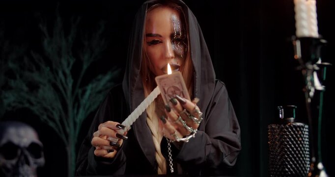 Witch performing ritual with tarot card and ceremonial dagger
