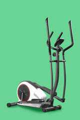 Modern elliptical machine on green background