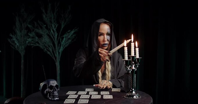 Witch holding ritual dagger over tarot spread
