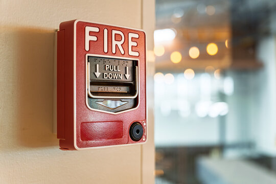 Fire alarm system notifier on wall background.Red wall-mounted fire alarm pull station in the office.Fire alarm systerm control and risk management concept.