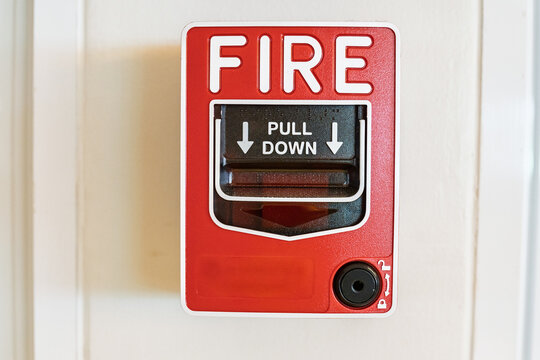 Fire alarm system notifier on wall background.Red wall-mounted fire alarm pull station in the office.Fire alarm systerm control and risk management concept.