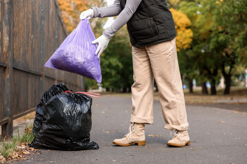 Woman leaving garbage bags on street for collection