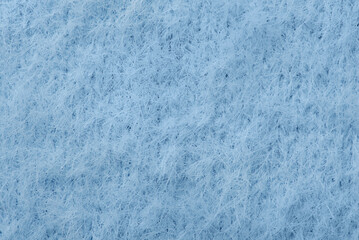 Blue background fabric warm fluffy macro photo. Texture of fabric of a warm sweater.