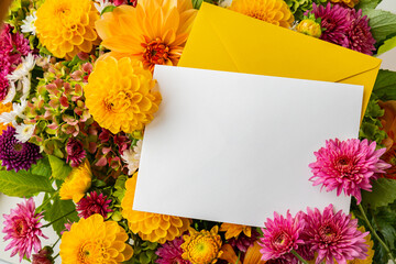 Empty white paper note copy space with yellow envelope Autumn Fall Bouquet for Thanksgiving holiday. Seasonal Warm colorful blossom flowers arrangement festive decoration. Selective focus