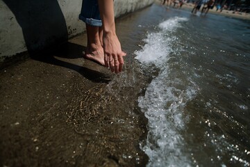 Barefoot Person's Hands And Feet At The Water's Edge, Touching The Gentle Waves Lapping On The Shore, A Calming Scene Of Relaxation