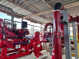 Powerful industrial diesel fire pump system with bold red engine, pipes, and control valves, ready for emergency fire suppression. This safety infrastructure ensures fire protection for factories 