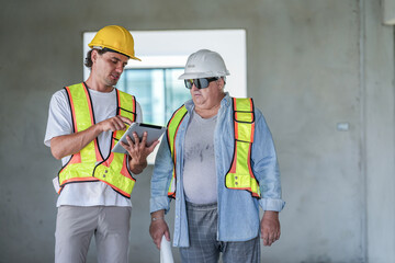 A site engineer and a foreman conduct a quality control check. The foreman uses a spirit level to verify alignment while the engineer reviews digital CAD plans on a laptop computer.