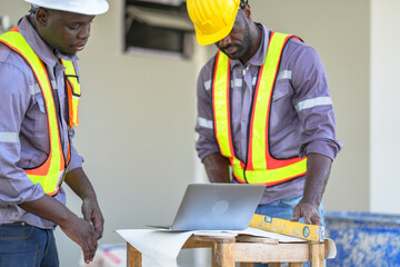 A site engineer and a foreman conduct a quality control check. The foreman uses a spirit level to...