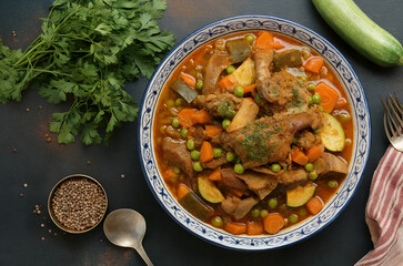 Algerian cuisine. Tagine jelbana. A meat and vegetable stew (potatoes, artichokes, carrots, peas, and others).

Top view