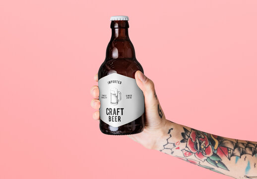Tattooed Hand Holding Craft Beer Mockup PSD