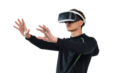 Young man wearing a vr headset with arms outstretched, wearing a black shirt, isolated on white