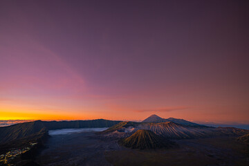 Bright morning colors on the horizon.The sun shines brightly over the sea of ​​mist at Bromo Volcano, Indonesia. At the top of the steep mountain you can see a volcanic crater and a sea of ​​mist.