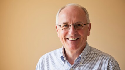 Obraz premium Portrait of a happy mature man with glasses smiling against a beige background in the studio