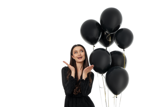 Young woman joyfully poses with black balloons, isolated, PNG