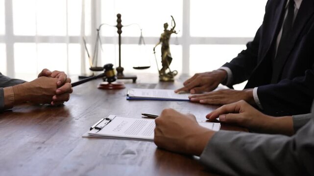 Businessman shaking hands after signing contract in a courtroom. Professional lawyers collaborating during legal consultation. - Powered by Adobe