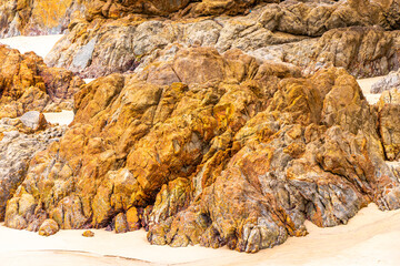 Rocky beach with rocks waves turquoise water in Patong Thailand.