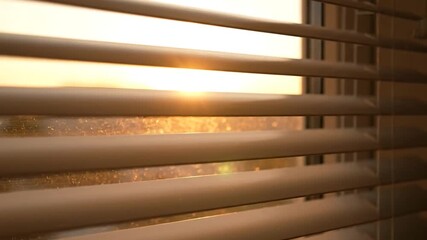 Close-up of Venetian blinds with sunlight streaming through the gaps, creating shadows and warm hues - Powered by Adobe