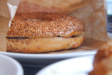 Freshly baked sesame bagel on a round plate