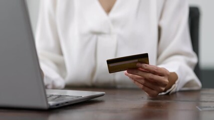 Businesswoman completing secure online payment, using laptop and credit card while working at modern office desk. - Powered by Adobe