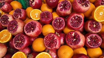 Fresh pomegranates and oranges at a vibrant market display