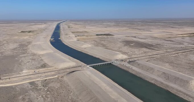 Aerial drone view circling a bridge on the Amudarja river canal, in sunny Balkh, Afghanistan