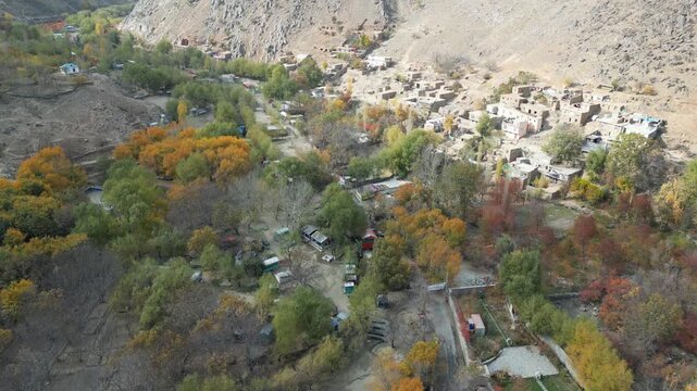 Aerial view backwards over a mountain town in Paghman, Afghanistan, fall day