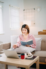 young asian woman working at home with laptop, freelancing concept