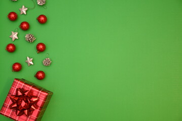 Minimal Christmas background with red and green colors, gift boxes, baubles, and stars. 