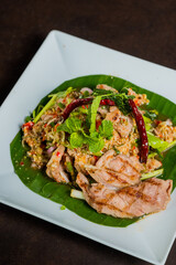 Delicious grilled pork salad on a plate with chili