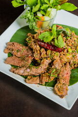 Close up shot of a beautifully presented dish with meat, herbs, and vegetables on a plate