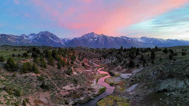 Aerial view ascending in front of a winding river, sundown in Hot Creek, CA, USA