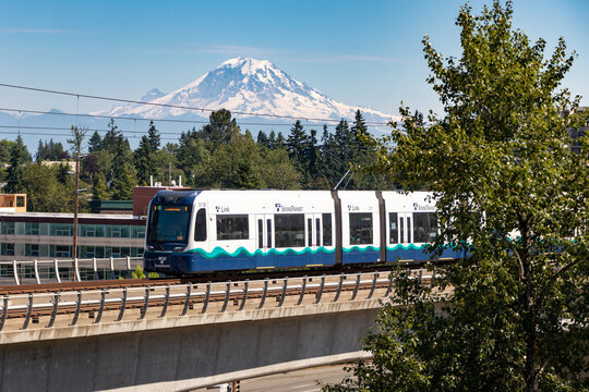 A Seattle Sound Transit Link light rail train on an elevated track with Mount Rainer in the background - Seattle, Washington, USA