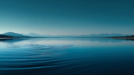 Obraz premium Minimal tranquil lake view merging softly with clear blue sky at horizon, blank open water in center forming smooth gradient tones and serene natural composition of calm simplicity.
