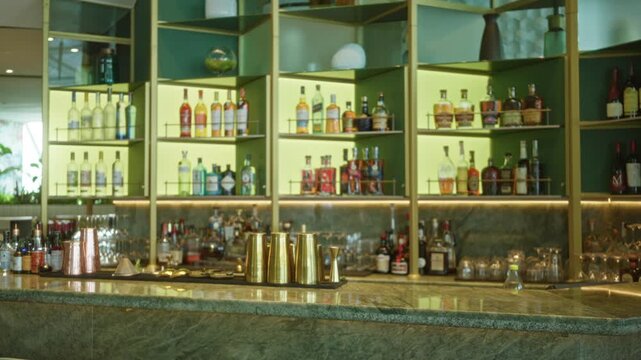Blurred bar shelving with bottles and marble countertop in soft bokeh defocused interior; background backplate copyspace calm.