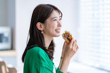 サンドイッチを食べる女性