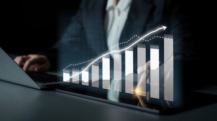 A business professional examines financial growth data displayed on a laptop, illustrating positive...