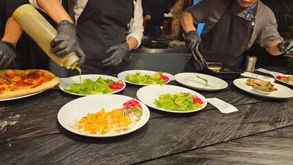Chef pouring sauce on a fresh salad with visually appealing.