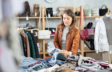 Elegance young girl buying jeans trousers in big clothing store. Shopping and seasonal sales concept