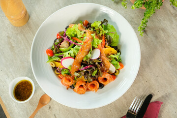 Fresh and vibrant salmon salad on a white plate, ready to be enjoyed. The salad is beautifully arranged with a variety of colorful vegetables and flavorful salmon
