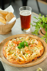 Delicious seafood pizza with a refreshing drink and snacks, perfect for a casual dining experience. It's a visually appealing scene that evokes feelings of satisfaction and enjoyment