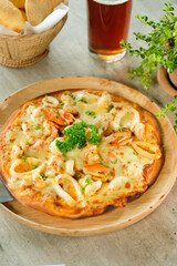 A close-up shot of delicious seafood pizza on wooden plate 
