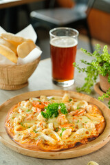 Delicious pizza and beer: A captivating shot of pizza with toppings, a glass of beer, and bread sticks, ready for an enjoyable meal