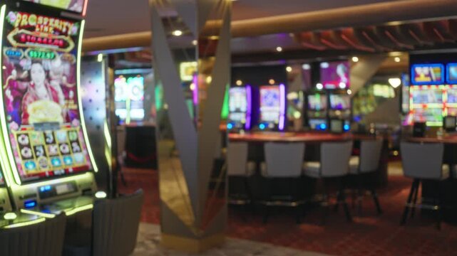 Blurred casino interior showing slot machines and defocused seating with soft bokeh, neon lights and mirrored columns; background backplate copyspace template.