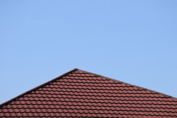 House roof with steel roofing sheet. Traditional metal shingle tiles. Gray modular tile effect roof panel. Profiled metallic corrugated pantile as clay or concrete slate. Building's covering