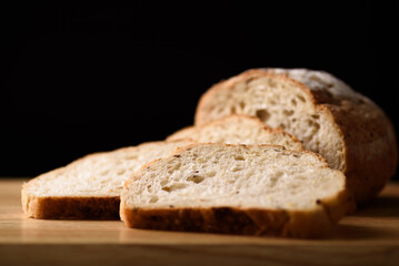 French country sourdough bread sliced on black background