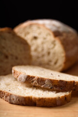 French country sourdough bread sliced on black background