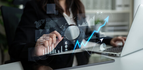 A professional businesswoman conducts data analysis using graphs and charts on her laptop, showcasing modern office elements and financial insights. Scalp