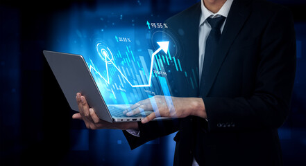 A professional businessman engages with a laptop showing a digital graph, highlighting growth and...